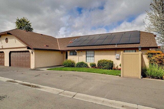 1010 S Clovis Ave Unit 101, Fresno, CA 93727 - view of front of property featuring an attached garage, solar panels, stucco siding, and driveway
