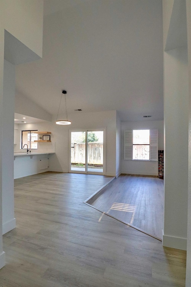 1010 S Clovis Ave Unit 101, Fresno, CA 93727 - unfurnished living room with wood finished floors, baseboards, and a sink