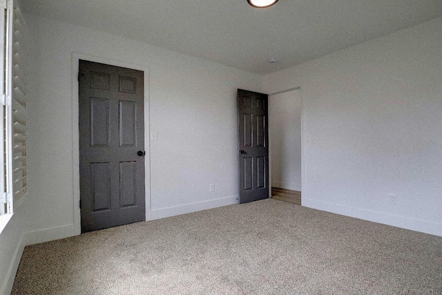 carpeted spare room with baseboards