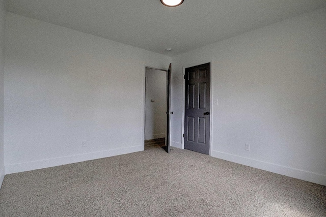 carpeted spare room with baseboards