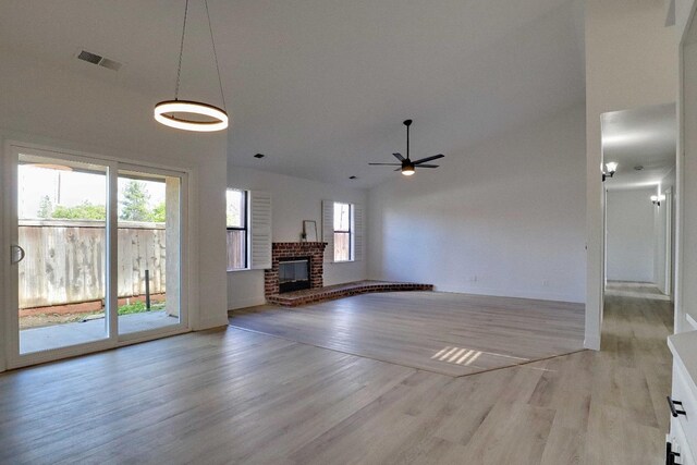 1010 S Clovis Ave Unit 101, Fresno, CA 93727 - unfurnished living room with light wood finished floors, a brick fireplace, a ceiling fan, baseboards, and vaulted ceiling