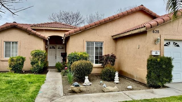 view of exterior entry featuring stucco siding, a tiled roof, and a garage