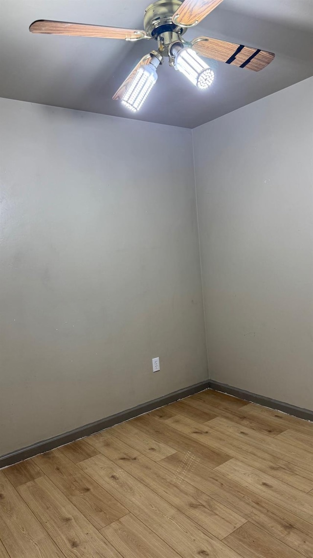 empty room featuring light wood-type flooring, baseboards, and ceiling fan