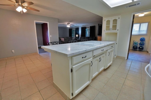 465 Mike Ct, Lemoore, CA 93245 - kitchen with ceiling fan, light tile patterned floors, white cabinets, and light stone counters