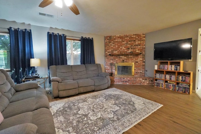 465 Mike Ct, Lemoore, CA 93245 - living room featuring wood finished floors, a ceiling fan, and a fireplace
