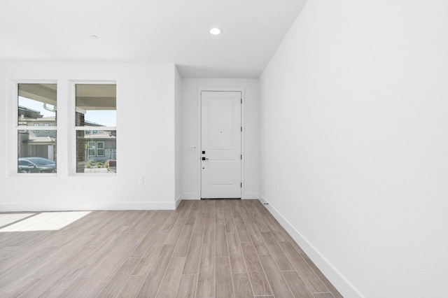 unfurnished room with light wood-type flooring, baseboards, and recessed lighting