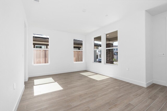 spare room featuring wood finished floors and baseboards