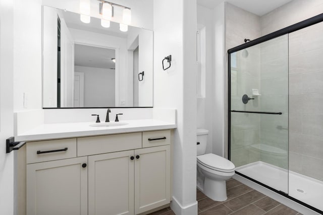 full bath featuring vanity, wood finish floors, a shower stall, and toilet