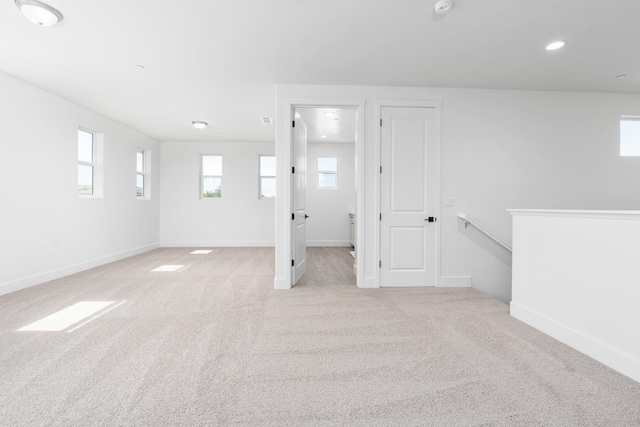 below grade area with recessed lighting, baseboards, and light carpet