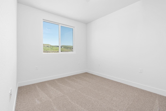 carpeted spare room featuring baseboards