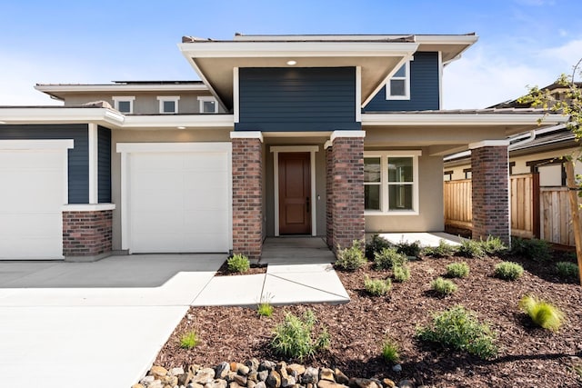 prairie-style home with driveway, an attached garage, fence, a porch, and brick siding