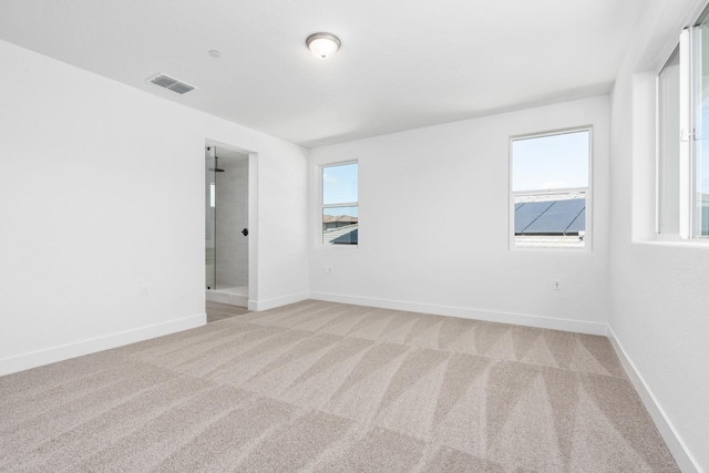 carpeted spare room with baseboards and visible vents