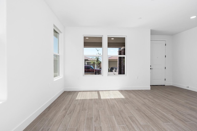 unfurnished room featuring recessed lighting, light wood-style flooring, and baseboards