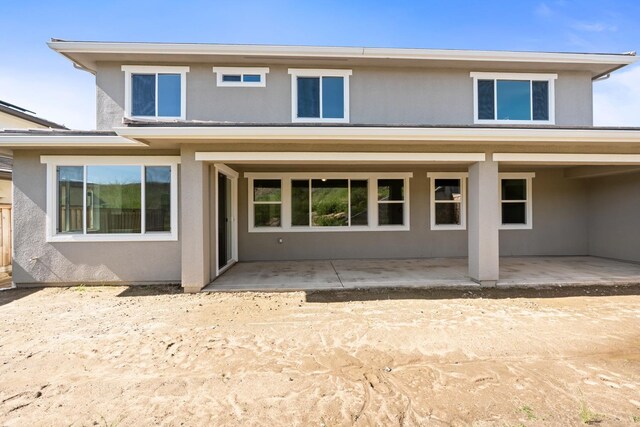 back of property featuring a patio and stucco siding