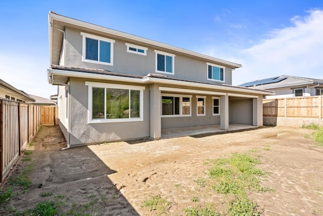 rear view of house with a patio area, a fenced backyard, and stucco siding