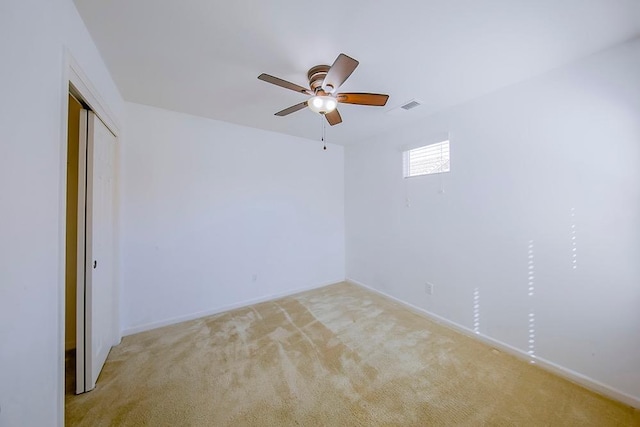 spare room featuring visible vents, baseboards, light colored carpet, and a ceiling fan