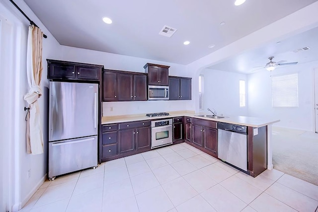 kitchen featuring visible vents, a sink, stainless steel appliances, a peninsula, and light countertops