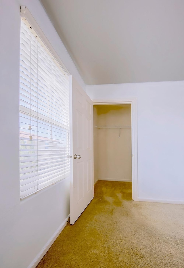 unfurnished bedroom with a closet, carpet flooring, and baseboards