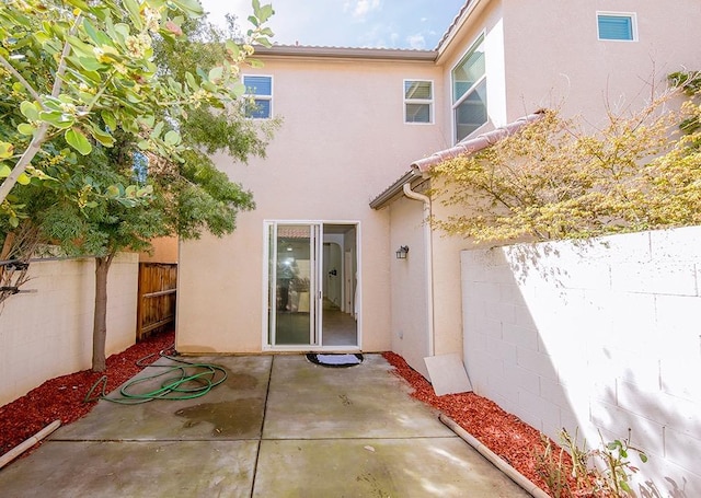 back of property featuring a patio area, fence, and stucco siding