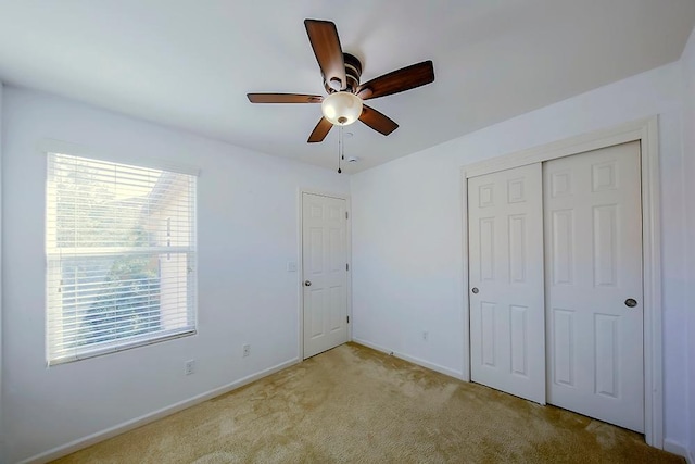 unfurnished bedroom featuring a closet, ceiling fan, baseboards, and carpet floors