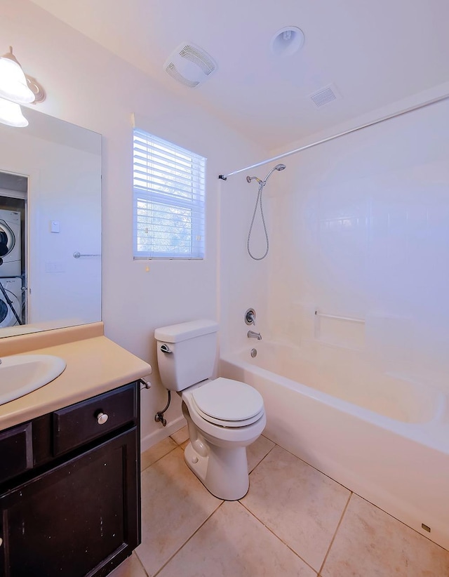 bathroom with vanity, visible vents, tile patterned flooring, stacked washer and clothes dryer, and toilet