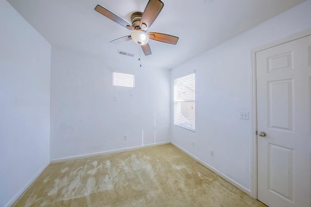 spare room featuring baseboards, carpet, visible vents, and ceiling fan