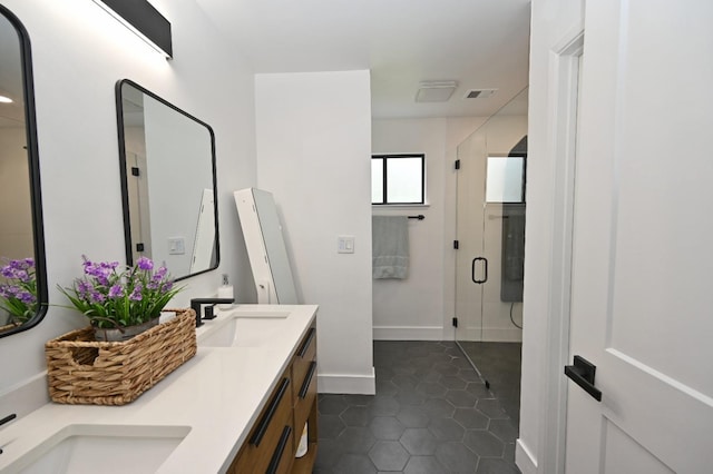 full bathroom with a sink, visible vents, tile patterned flooring, a shower stall, and double vanity
