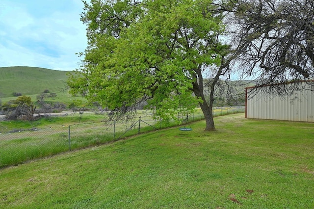 view of yard featuring fence and an outdoor structure