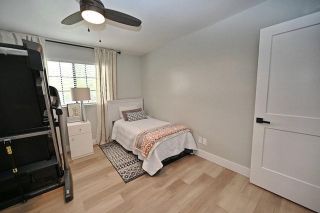 bedroom featuring baseboards, light wood-type flooring, and a ceiling fan