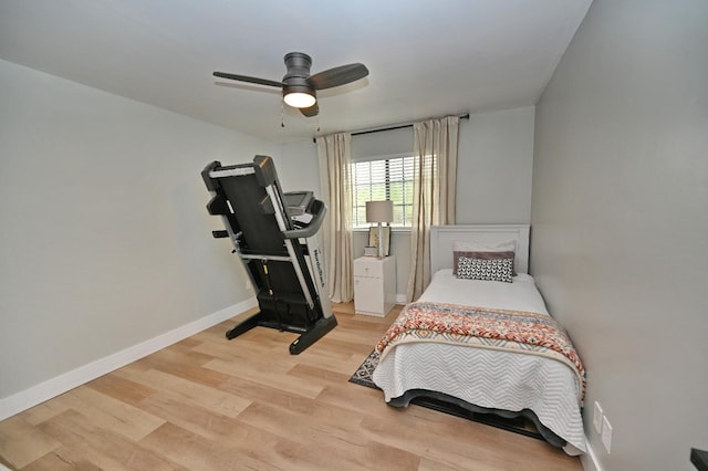 bedroom featuring baseboards, light wood-type flooring, and a ceiling fan