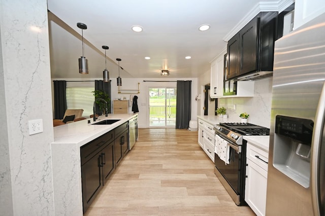 kitchen featuring hanging light fixtures, a sink, stainless steel appliances, light wood-style floors, and recessed lighting