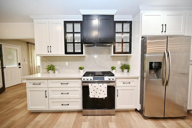 kitchen featuring backsplash, stainless steel appliances, extractor fan, and glass insert cabinets