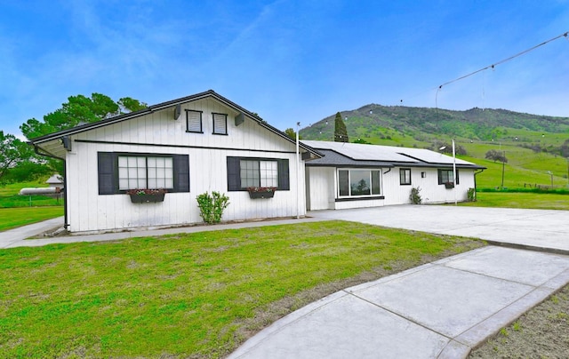 25190 Elwood Rd, Sanger, CA 93657 - modern farmhouse style home with solar panels, a front yard, a mountain view, and concrete driveway