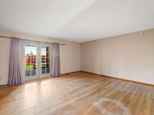 9414 E Belmont Ave, Sanger, CA 93657 - spare room featuring light wood-style flooring, a textured ceiling, and french doors