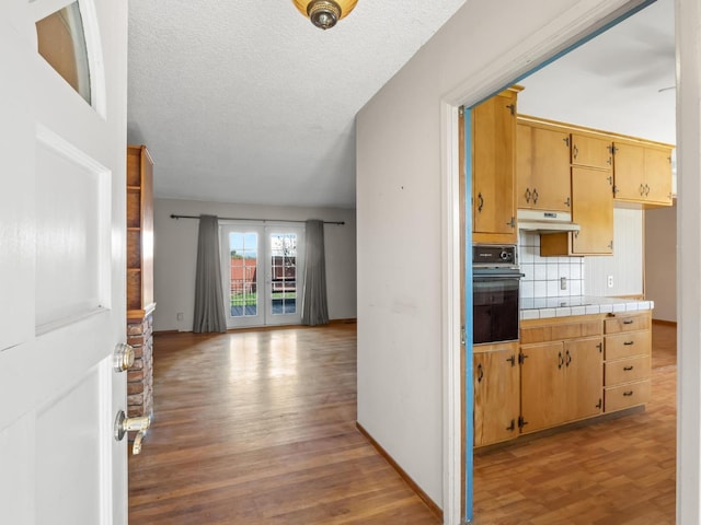9414 E Belmont Ave, Sanger, CA 93657 - hallway with light wood finished floors and a textured ceiling