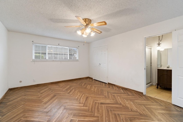 210 S Caesar Ave, Fresno, CA 93727 - unfurnished bedroom featuring baseboards, ensuite bath, a closet, a ceiling fan, and a textured ceiling