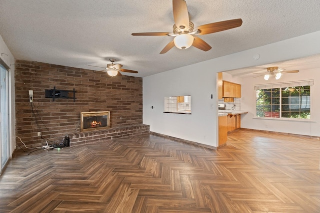 210 S Caesar Ave, Fresno, CA 93727 - unfurnished living room with ceiling fan, a textured ceiling, baseboards, and a fireplace