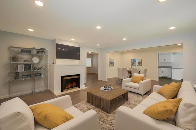 living area with a fireplace, baseboards, wood finished floors, and recessed lighting