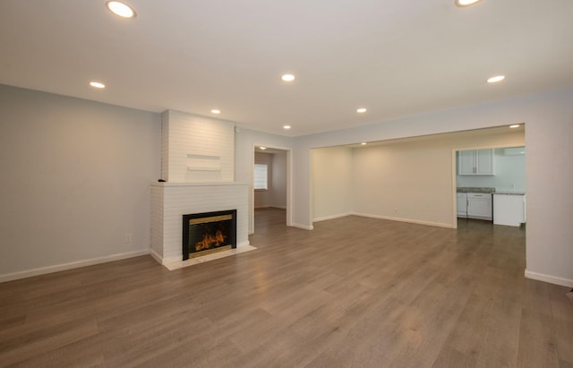 467 E San Bruno Ave, Fresno, CA 93710 - unfurnished living room featuring a brick fireplace, recessed lighting, baseboards, and dark wood-style flooring
