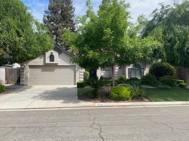 4240 W Sierra Ave, Fresno, CA 93722 - obstructed view of property with concrete driveway, a garage, and stucco siding
