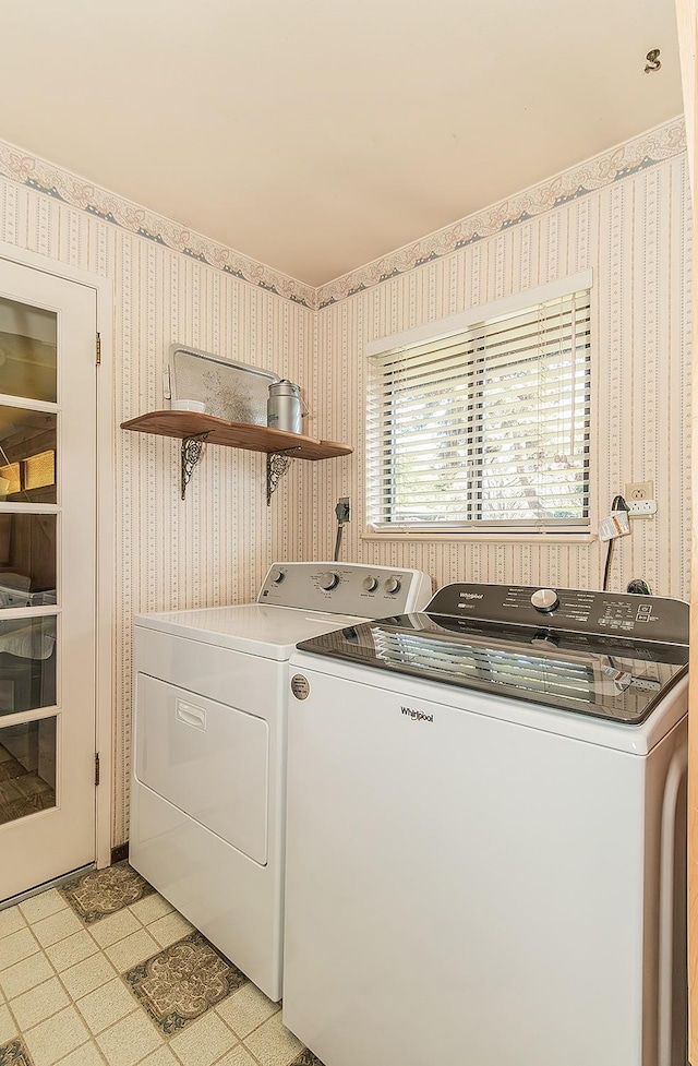washroom with laundry area, washer and dryer, and wallpapered walls