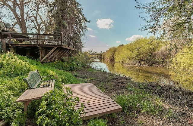 view of yard with stairway and a deck with water view