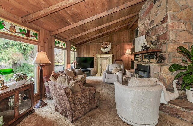 living room featuring wood walls, wood ceiling, lofted ceiling with beams, and carpet floors