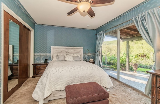 carpeted bedroom with a closet, wallpapered walls, ceiling fan, and access to outside