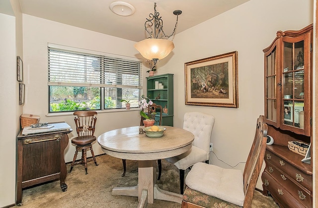 dining room with baseboards and light carpet