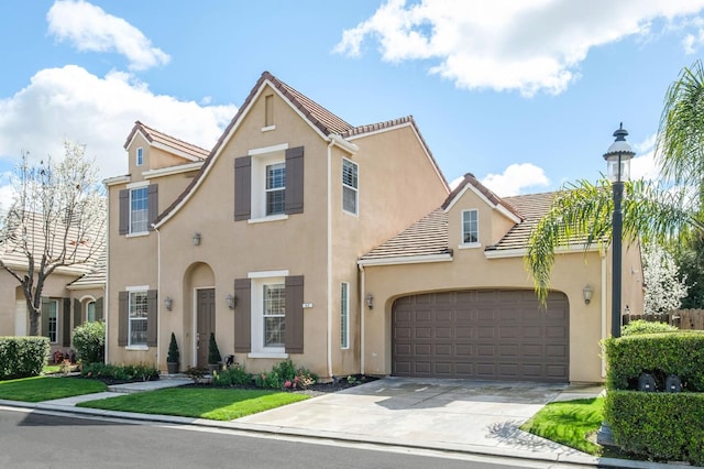 view of front of home featuring a garage, driveway, a tiled roof, and stucco siding