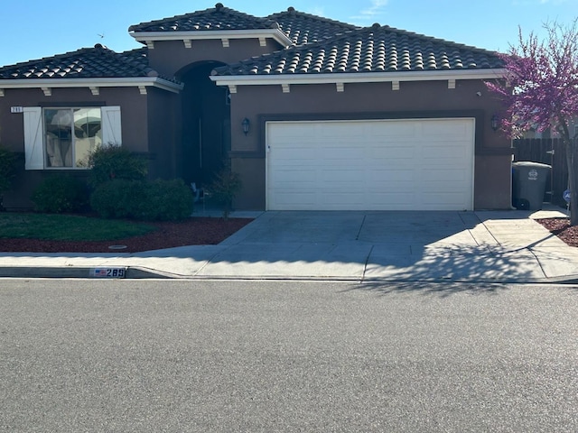 289 S Timberline Dr, Madera, CA 93637 - mediterranean / spanish-style home with concrete driveway, stucco siding, an attached garage, and a tile roof