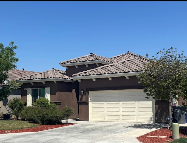 289 S Timberline Dr, Madera, CA 93637 - mediterranean / spanish-style house featuring driveway, an attached garage, stucco siding, and a tiled roof