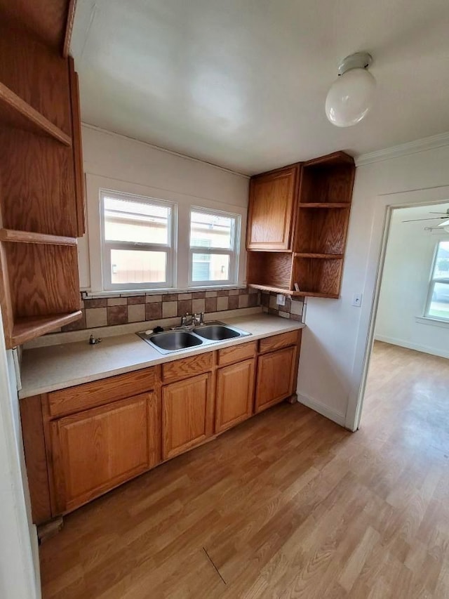 347 Coolidge St, Coalinga, CA 93210 - kitchen with light countertops, backsplash, a sink, open shelves, and light wood-style flooring