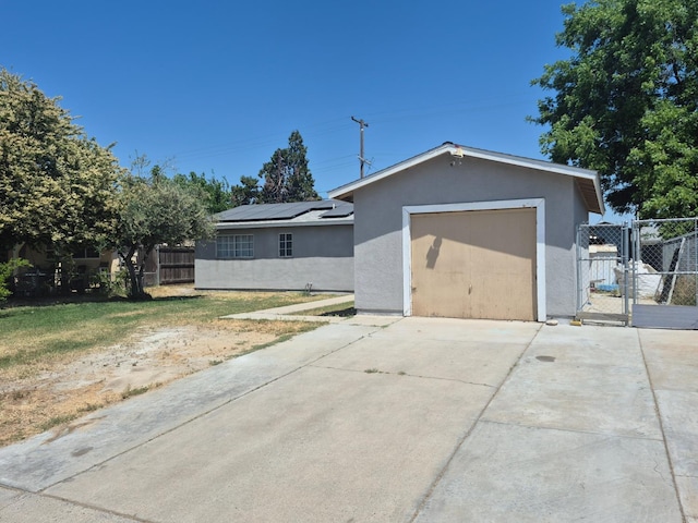 27261 Stanford Ave, Madera, CA 93637 - ranch-style house with stucco siding, concrete driveway, a gate, and solar panels